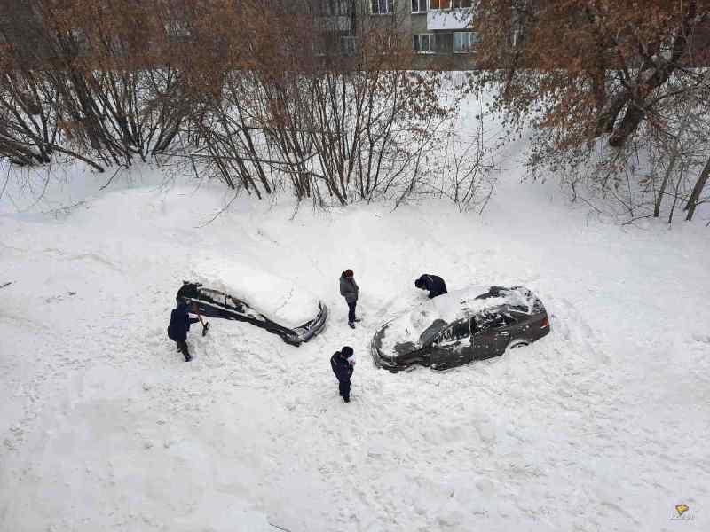 Снежная лавина накрыла парковку в Новосибирске: засыпаны две машины