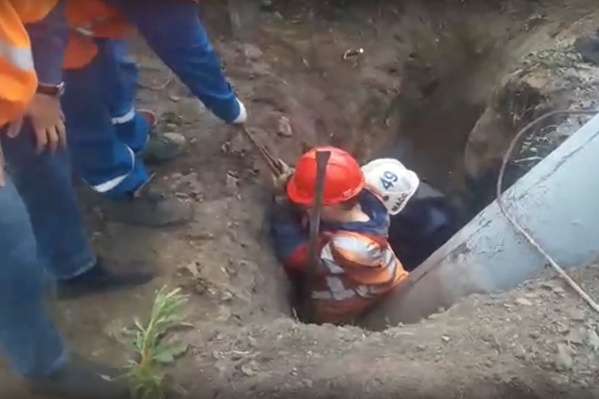 Молодого рабочего зажало столбом в яме — видео, на котором мужчину откапывают коллеги и спасатели